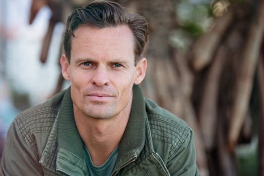 Close-up portrait of a man wearing a casual jacket outdoors.